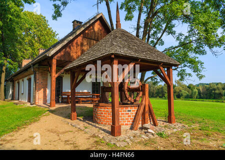 Pozzo di acqua di una tradizionale casa rurale nel villaggio di Radziejowice su soleggiate giornate estive, Polonia Foto Stock