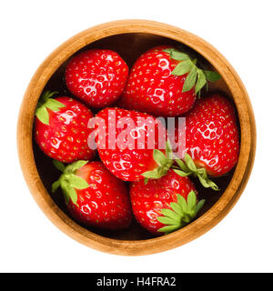 Giardino di fragole in una ciotola di legno su sfondo bianco. Fresche e mature rosso brillante frutti di Fragaria ananassa. Foto Stock