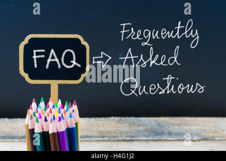 Acronimo di Business FAQ Domande frequenti scritto con un gessetto su legno mini etichette lavagna Lavagna e background. Foto Stock