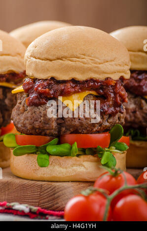 Carni bovine i cursori con fatti in casa salsa barbecue, cheddar, pomodorini e microgreens Foto Stock