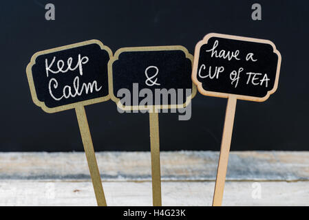 Mantenere la calma e di avere una tazza di tè messaggio scritto con un gessetto su mini etichette di Blackboard Foto Stock