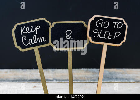Mantenere la calma e di andare a dormire messaggio scritto con un gessetto su mini etichette di Blackboard Foto Stock