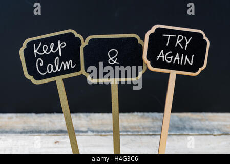 Mantenere la calma e provare di nuovo messaggio scritto con un gessetto su mini etichette di Blackboard Foto Stock