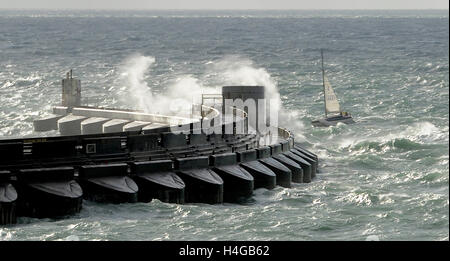 Brighton SUSSEX REGNO UNITO 16 Ottobre 2016 - Uno yacht con attenzione si fa strada in Brighton Marina questa mattina in condizioni di vento forte come onde enormi crash al di sopra del braccio occidentale Credito: Simon Dack/Alamy Live News Foto Stock