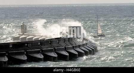 Brighton SUSSEX REGNO UNITO 16 Ottobre 2016 - Uno yacht con attenzione si fa strada in Brighton Marina questa mattina in condizioni di vento forte come onde enormi crash al di sopra del braccio occidentale Credito: Simon Dack/Alamy Live News Foto Stock