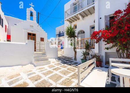 Quadrato con chiesa sulla strada imbiancate con la tipica architettura Greca nella bellissima città di Mykonos, Cicladi, Grecia Foto Stock