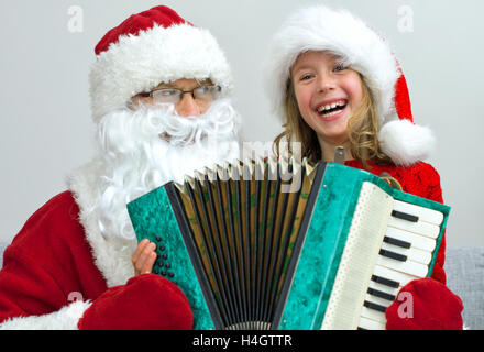 Babbo Natale e la bambina a suonare la fisarmonica a Natale. Foto Stock