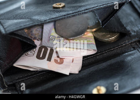 Immagine del portamonete aperto/wallet rivelando allentato cambiare & denaro - metafora per l' aumento del costo della vita' , la convenienza, i prezzi del negozio, basso reddito concetto. Foto Stock