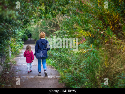 Madre e figlia insieme a piedi su un sentiero di campagna in autunno Foto Stock