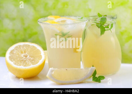 Limonata organico servita in caraffa e vetro con foglie di menta Foto Stock