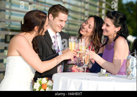 Sposa e amici bicchieri tintinnanti con champagne Foto Stock