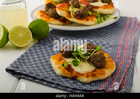 Mini pizza con polpette di carne, il succo di lime - fresche, microgreens sulla parte superiore, cibo organico, carni bovine Foto Stock