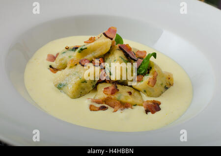 Gnocchetti di spinaci con salsa di Parmigiano e rabboccato con pancetta, pulire serve, ingredienti in background Foto Stock