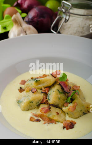 Gnocchetti di spinaci con salsa di Parmigiano e rabboccato con pancetta, pulire serve, ingredienti in background Foto Stock