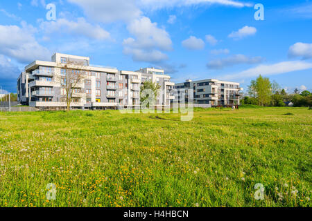 Moderno edificio di appartamenti sul prato verde con fiori in città di Cracovia, in Polonia Foto Stock