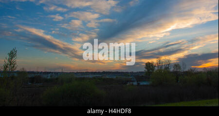 I bei colori del cielo e delle nubi come il sole tramonta sulla campagna Foto Stock