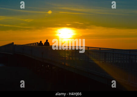 Brillante alba sulle acque del Lago Huron al molo di Oscoda, Michigan Foto Stock