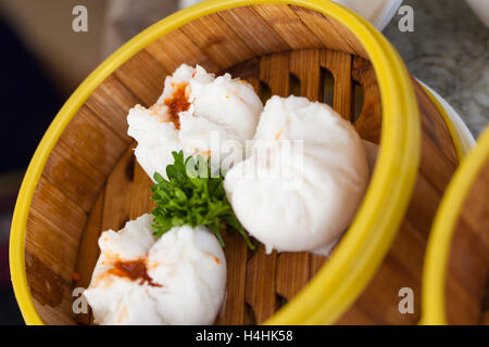 Vaporizzato Chinese bun o saipao rosso ripiene di carne di maiale stagionatura decorate nizza nel sistema di cottura a vapore locale di bambù Foto Stock