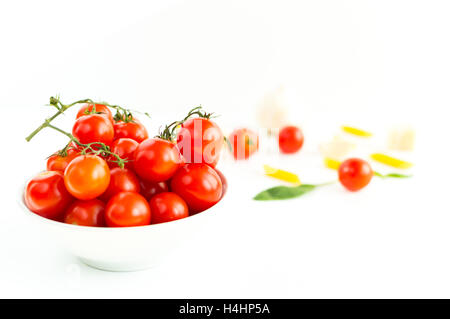 Italiano di pomodori rossi vicino il cibo con pasta, basilico foglie, formaggio, isolati su sfondo bianco Foto Stock