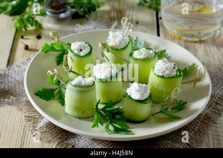Il cetriolo rotoli farciti con il formaggio feta, aneto e olive su un tavolo in stile rustico. Foto Stock