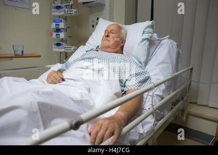 Uomo anziano (83) recuperare nel suo letto di ospedale nella cardiac ward alta unità di dipendenza da una seria operazione al cuore, REGNO UNITO Foto Stock
