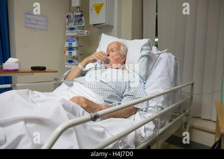 Uomo anziano (83) recuperare nel suo letto di ospedale nella cardiac ward alta unità di dipendenza da una seria operazione al cuore, REGNO UNITO Foto Stock