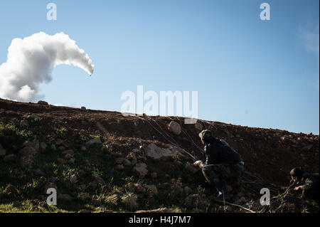 Rocket fire - 16/01/2013 - Siria / Aleppo / Kwiriss Airport - un combattente di Abo Baker brigata ( Libero esercito siriano) prende rifugio come lui spara un razzo su siriano truppe governative difendendo la Kwiriss aeroporto militare, in Al-Bab nei pressi di Aleppo. - Edouard Elias / le Pictorium Foto Stock