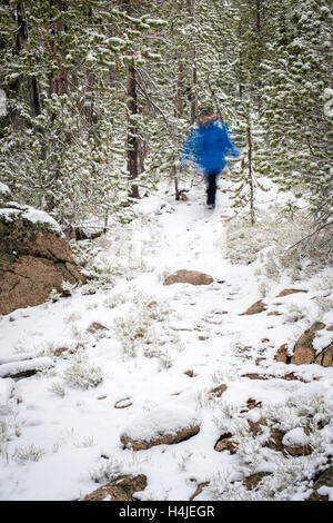 Inverno escursionista trekking giù per un sentiero in una sfocatura fashion Foto Stock