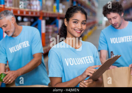 Ritratto di volontario sorridente holding negli appunti Foto Stock