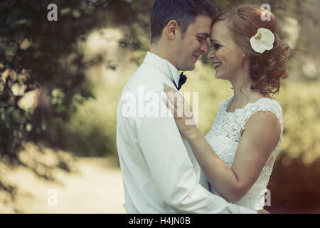 Bella Sposa e lo sposo kissing all'aperto dopo la cerimonia Foto Stock