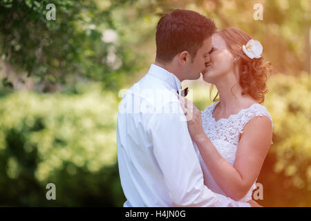 Bella Sposa e lo sposo kissing all'aperto dopo il matrimonio Foto Stock