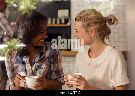 Amici di sesso femminile interagire gli uni con gli altri mentre un caffè Foto Stock