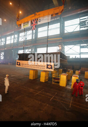 La parte anteriore di una sezione della chiglia delle RRS sir David Attenborough è abbassata nella costruzione Hall a Cammell Laird nel Birkenhead, come parte del processo di costruzione. Foto Stock