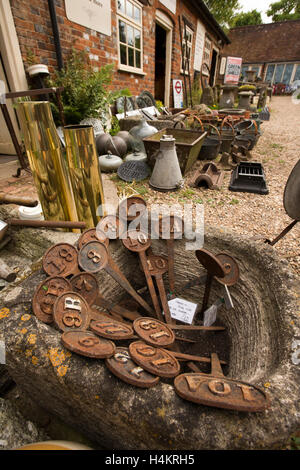 Inghilterra, Berkshire, Hungerford, High Street, sotto le scale, centro di antiquariato, stock nel cortile esterno, numeri di metallo nel recipiente di pietra Foto Stock