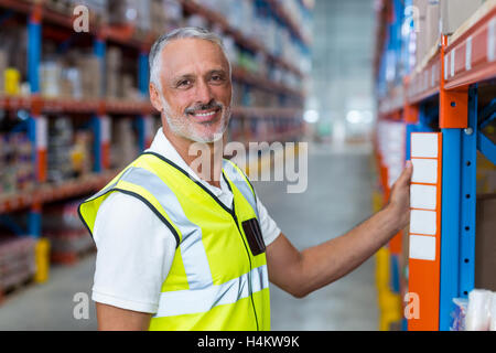 Ritratto di lavoratore di magazzino in piedi vicino a ripiano Foto Stock