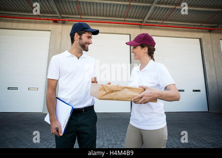 Consegna Felice l uomo e la donna in piedi con gli appunti e i pacchi Foto Stock