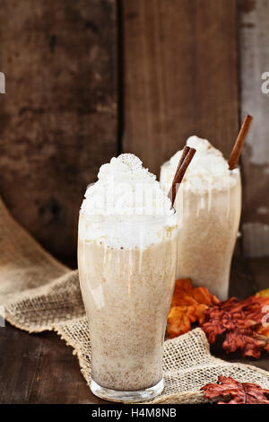 La zucca Spice caffè ghiacciato con panna montata e cannella contro un sfondo rustico. Profondità di campo con selective foc Foto Stock