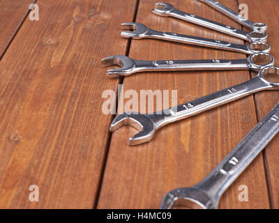 Set di wrenchs metallo cromato strumenti chiave su una superficie di legno Foto Stock