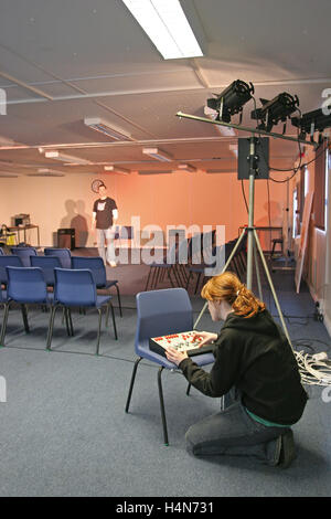 Uno studente opera di illuminazione teatrale nella scuola di dramma studio. Mostra dimmer e faretti Foto Stock