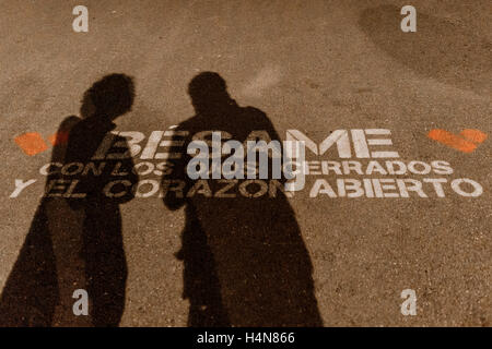 Silhouette di un paio di lettura di una frase di amore scritto sul pavimento, Laredo, Cantabria, Spagna, Europa. Foto Stock