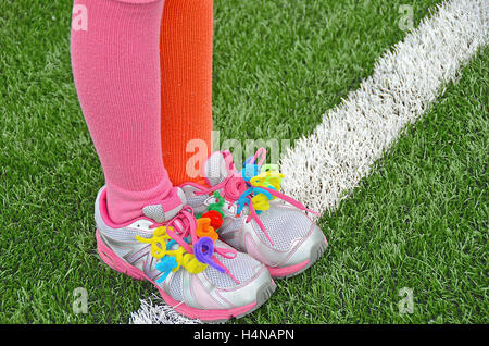 Tubo colorato cleaner lacci della scarpa sulla scarpa sportiva sul campo di calcio Foto Stock