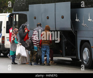 Una famiglia di schede madri con un pullman per lasciare la giungla campo di migranti a Calais, Francia, per iniziare una nuova vita nel sud della Francia come i piani sono fatti per demolire il camp nelle prossime settimane. Foto Stock