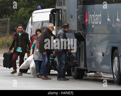 Una famiglia di schede madri con un pullman per lasciare la giungla campo di migranti a Calais, Francia, per iniziare una nuova vita nel sud della Francia come i piani sono fatti per demolire il camp nelle prossime settimane. Foto Stock