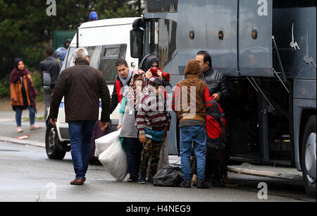 Una famiglia di schede madri con un pullman per lasciare la giungla campo di migranti a Calais, Francia, per iniziare una nuova vita nel sud della Francia come i piani sono fatti per demolire il camp nelle prossime settimane. Foto Stock