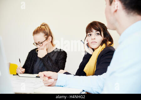 Tre persone sedute a un incontro di affari, due donne e un uomo. Foto Stock