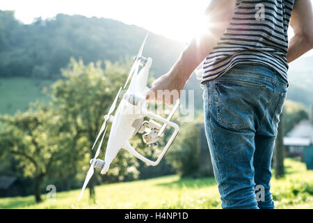 Irriconoscibile giovane azienda drone. Soleggiato verde natura. Foto Stock