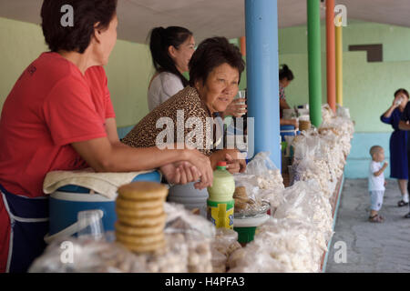 Le donne vendono kumis latte di cavallo e kurt palline di formaggio a lato strada sostare vicino Altyn Emel Park Kazakistan Foto Stock