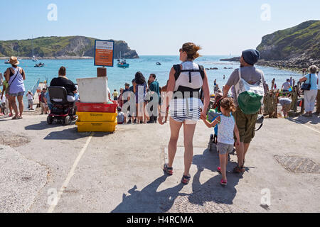 Le persone che si godono la giornata di sole a Lulworth Cove nel Dorset, England Regno Unito Regno Unito Foto Stock
