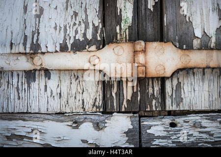 Dettaglio delle vecchie persiane in legno con ferro arrugginito e cerniera pareti scrostate. Toulouse, Francia. Foto Stock