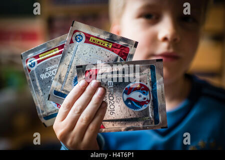 Un bambino di 8 anni è il ragazzo che mostra il suo pacco di panini scambio di carte per l'EURO 2016 UEFA campionato europeo di calcio. Foto Stock